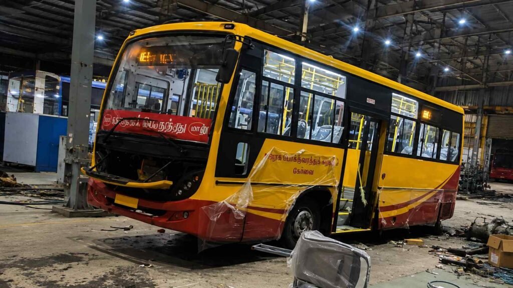 Tamil Nadu MTC mini bus painted in TVK party flag colors yellow and red.